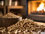 Un mucchio di pellet di legno su un tavolo, con un camino acceso sullo sfondo. L'immagine evoca il tema dell'andamento prezzo pellet.