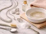 Set per come pulire l'argento gioielli: collana, orecchini, anello, bicarbonato, spazzolino e ciotola con acqua saponata.