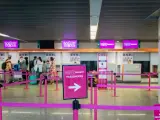 Kasa Wizz Air, gdzie pasażerowie dokonują self check-in. Różowe taśmy wyznaczają kolejkę do stanowisk odprawy.