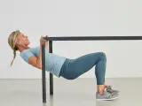 Kvinna utför overhead triceps extension vid en ställning.