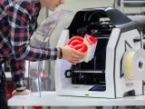 Inżynier wyjmuje z drukarki 3D skomplikowany element, pokazując potencjał druku 3D w przemyśle.