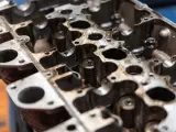 Metalowa głowica silnika z widocznymi zaworami i sprężynami. Widać otwory, przez które przepływa mieszanka paliwowo-powietrzna do każdego **cylinder**.