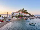 Widok na zatokę Vathy na Samos z łodziami i budynkami na tle wzgórza.