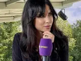 Maja Strzelczyk, dziennikarka sportowa, z mikrofonem Polsat Sport. W tle zielone drzewa i niebo.
