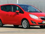Czerwona Opel Meriva z czarnym dachem, idealna do miasta. Jaki silnik benzynowy wybrać? Ten model oferuje komfort i praktyczność.