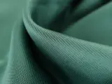 Gładka, zielona tkanina lyocell, przyjemna w dotyku. Dowiedz się, lyocell co to za materiał i dlaczego jest tak ceniony.