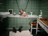 Kobieta w wannie, obok zdjęcie mężczyzny w mundurze. Buty i ubrania na podłodze. Zobacz to lee na własne oczy.