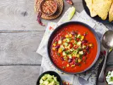 Prawdziwa zupa meksykańska z fasolą, kukurydzą i awokado, podana z nachos i serem.