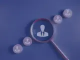 Lupa powiększa sylwetkę pracownika, analizując fluktuację pracowników i ich rotację.
