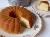 En gyllene sockerkaka i en vacker sockerkaka form, med en bit uppskuren. En klassiker som doftar hembakat.