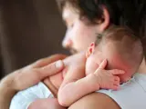 Padre abbraccia neonato. Osservare attentamente i sintomi autismo nel neonato di 3 mesi, come la mancanza di contatto visivo o risposte emotive atipiche.