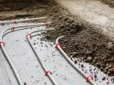 Instalacja ogrzewania podłogowego z rurkami mocowanymi do folii, gotowa do zalania jastrychem.
