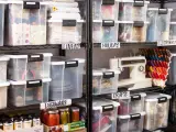 Organized basement storage ideas with labeled clear bins for linens, holiday items, crafts, electronics, and dishware.