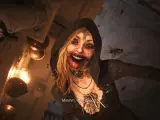 Przerażająca postać z Resident Evil Village, otoczona przez muchy, z krwią na ustach. Czas gry wciąga w mroczny świat.