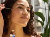Donna applica un siero viso con contagocce, scoprendo i benefici della niacinamide cos'è per una pelle luminosa.