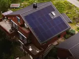 Dom z panelami fotowoltaicznymi na dachu. To rozwiązanie, co to fotowoltaika, pozwala na produkcję własnej energii elektrycznej ze słońca.