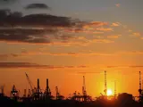 Silhouetten von Kränen im Hamburger Hafen bei Sonnenuntergang. Perfekt für die Pfingstferien in Hamburg.