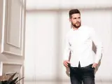 Mężczyzna w białej koszuli i jeansach, prezentujący styl slim fit.