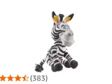 Pluszowa zebra z Madagaskaru, Marty, siedzi z szeroko otwartymi oczami i uśmiechem.