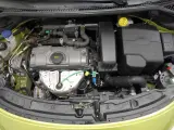 Silnik Peugeot 207, widok z góry. Widać elementy układu dolotowego, pokrywę zaworów i alternator.