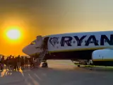 Ryanair loty za 1 zł – pasażerowie wsiadają do samolotu o zachodzie słońca.