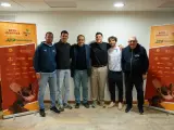 Roberto Carballes Baena posa con otros hombres frente a un cartel del Open Menorca ATP Challenger 100.