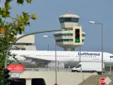 Lufthansa samolot na tle wieży kontroli lotów. To największe lotnisko w Europie, gdzie ruch jest zawsze intensywny.