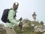 Randonneur ajustant son réglage bâton de marche, prêt à affronter la brume avec sa lampe frontale.