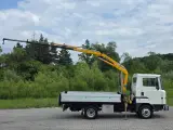Biała ciężarówka z żółtym dźwigiem, gotowa do pracy. Ten Nissan Atleon z pewnością ułatwi transport.