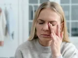 Kobieta zamyka oczy, pocierając je palcami. Czuje się, jakby miała śnieg optyczny.