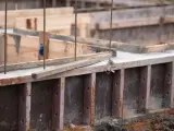 Drewniany szalunek czeka na beton. Widać zbrojenie i świeży beton.