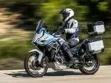 Motociclista con casco blanco y equipo de aventura sobre una moto Zontes, lista para explorar caminos. Motos adventure A2 perfectas para tu próxima travesía.