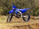 Niebieski motocykl Yamaha WR250F na tle leśnym. Szczegółowe yamaha wr 250 f dane techniczne dostępne dla miłośników off-roadu.