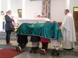 Dzieci klęczą pod zielonym welonem, odmawiając modlitwę do Matki Bożej z Guadalupe. Kapłan czuwa obok.