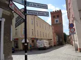 Ulica z wieżą i drogowskazami do Sądu Rejonowego, Krzywej Wieży i Zamku. Odkryj mało znane miejsca na Dolnym Śląsku.