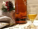 Liquore genziana ricetta: bottiglia ambrata, bicchierino dorato e decorazione natalizia.