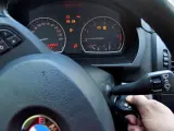 Ręka wsuwa kluczyk do stacyjki, by dowiedzieć się, jak odpalic auto. Na desce rozdzielczej świecą kontrolki.