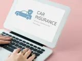 Kobieta wpisuje w laptopie frazę "ile kosztuje ubezpieczenie samochodu pierwszy raz". Na ekranie widnieje grafika samochodu z tarczą i hasło "CAR INSURANCE".