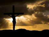 Silhouette of Jesus on the cross against a dramatic sky. His sacrifice shows Jesus died for our sins, offering hope.