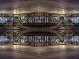 Nocne miasto z żółtym tramwajem i ludźmi. Kompozycja symetryczna tworzy surrealistyczny, odbity świat.