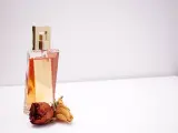 Elegante flacone di profumo dorato con rose secche, un'ispirazione su come scegliere un profumo che ti rappresenti.