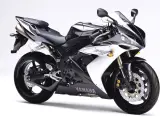 Sportowy motocykl Yamaha R1, jedna z wielu generacji, w kolorze czarno-białym, prezentuje się dynamicznie na białym tle.