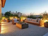 Terrasse moderne avec mobilier de jardin, plantes et éclairage d'ambiance sur un sol en gravier. Le prix du gravier m3 est un détail à considérer pour un tel aménagement.