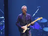 Eric Clapton gra na gitarze, wykonując swoje legendarne utwory.