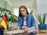 Dziewczyna z papugą na ramieniu uczy się niemieckiego. Może szuka inspiracji na piosenkę na urodziny po niemiecku?