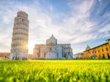 Torre di Pisa e Duomo, tra i più bei posti da visitare in Toscana, con un prato verde brillante e cielo azzurro.
