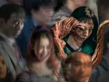 Dziewczyna z potwornym pasożytem wychodzącym z twarzy, otoczona przez zamazane postacie. Plakat serialu "Głód" (ang. "The Host") na Netflix.