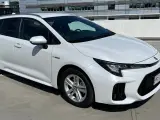 Biały Suzuki Swace Hybrid na parkingu. Elegancki kombi z nowoczesnym designem, gotowy na każdą podróż.