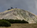 Schronisko i obserwatorium na szczycie w Karkonoszach, z widoczną kolejką linową i kamienistym zboczem.