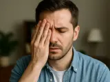Uomo con mano sull'occhio, espressione di stanchezza o dolore. L'angolo visivo è ristretto, focalizzato sul disagio.